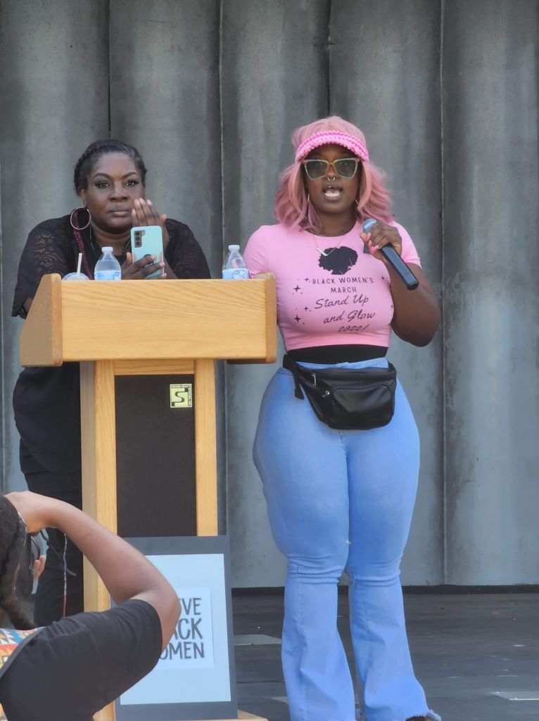 Speaker standing next to podium during Black Women's March 2022